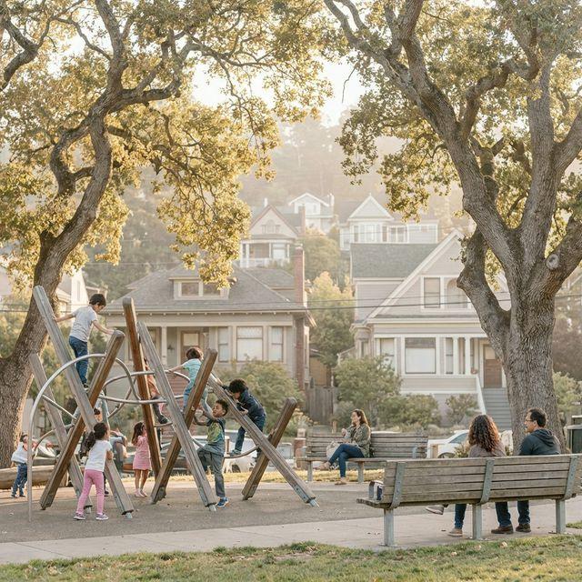 Kids playing on a local playground in Rockridge while parents watch from nearby benches